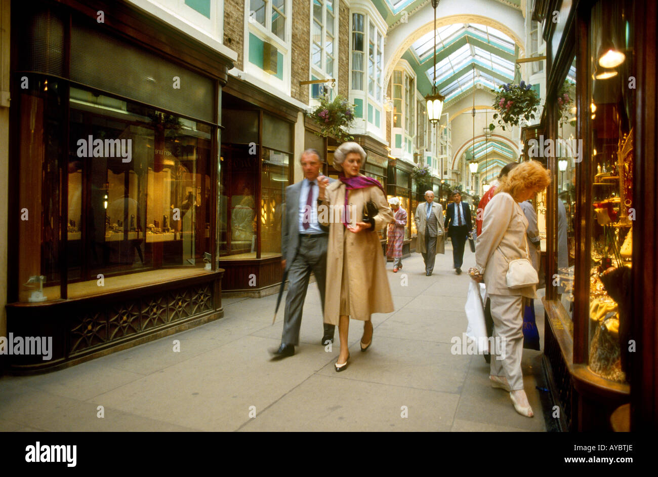 Man & woman strolling along historical exclusive shopping arcade Burlington Arcade, Mayfair linked to Savile Row tailors London Stock Photo