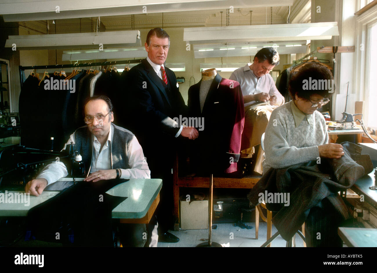 Angus Cundey boss of historical family bespoke tailors Henry Poole Co in the upstairs workroom with staff Savile Row Stock Photo