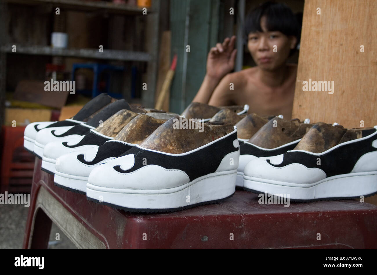 The young shoemaker selling his platform style shoes on the Bui Vien street in the backpacker area of Pham Ngu Loa, Vietnam, Jul Stock Photo