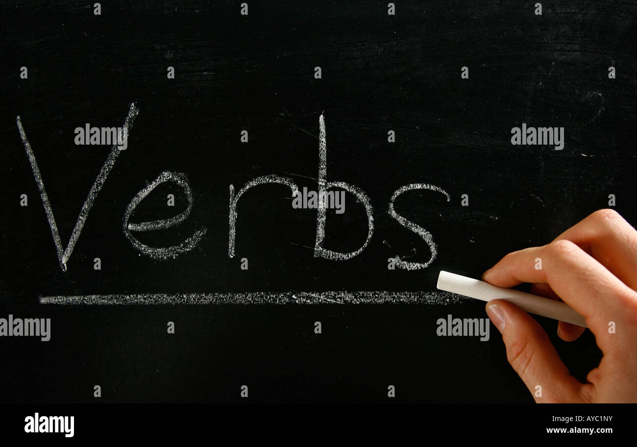 The word verbs written by hand in chalk on a blackboard Stock Photo Alamy