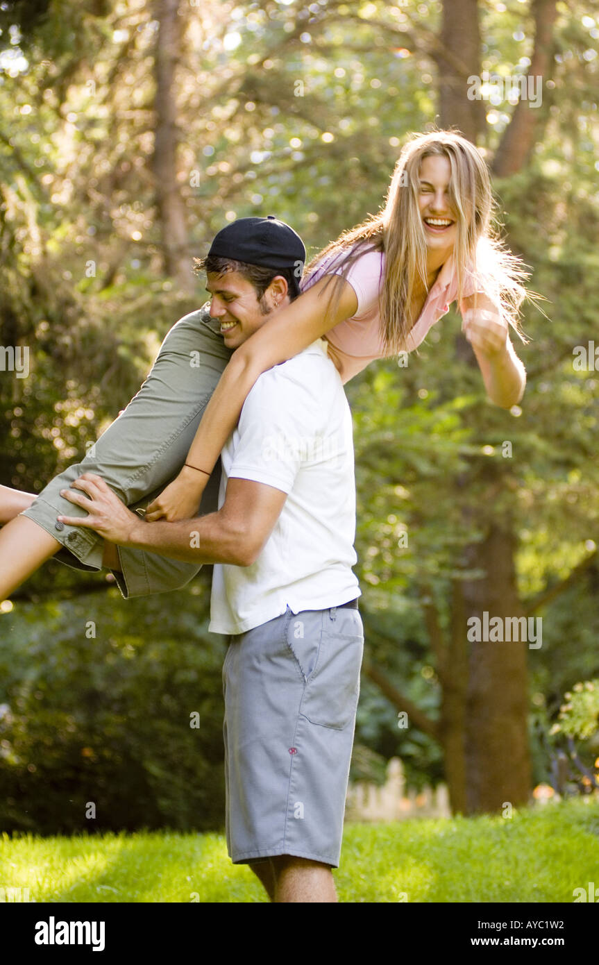 Playful teenage boy lifting laughing teenage girl. Stock Photo
