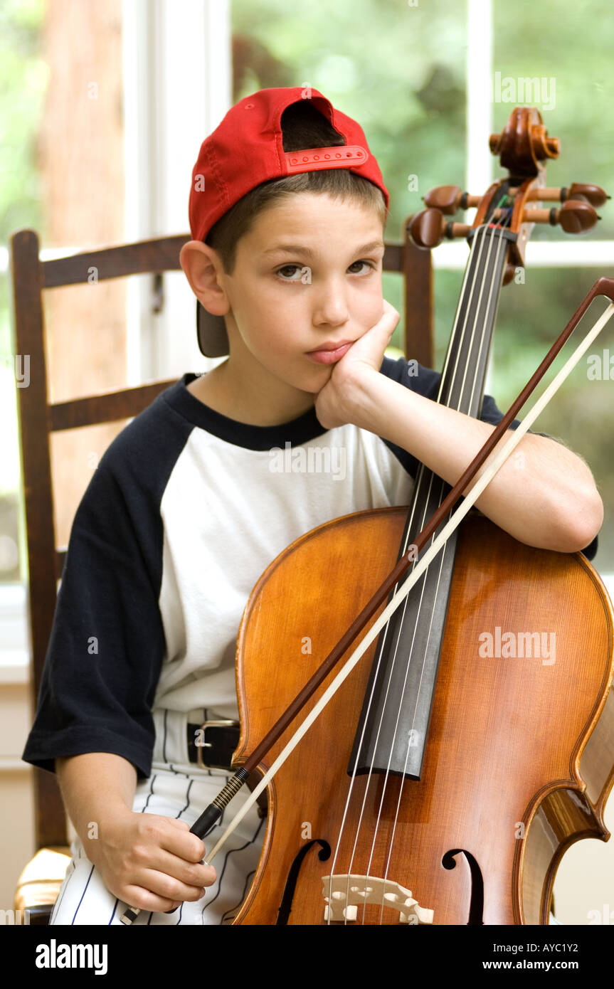 Unhappy boy having to do his cello lessons Stock Photo