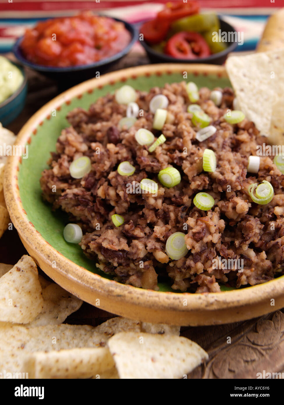 Refried beans with tacos and salsa guacamole peppers Stock Photo Alamy