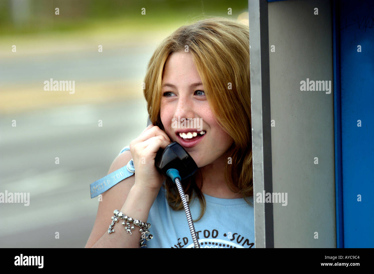 13 year old talking to friend on telephone at disappearing push button ...