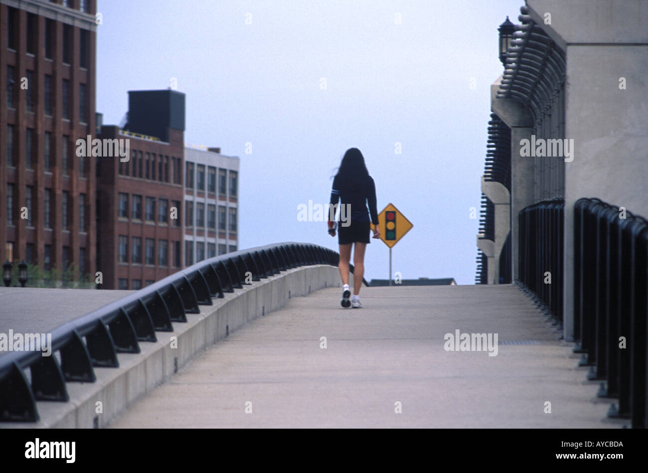 A young woman walks across the Berkeley Street Bridge into South Boston Stock Photo