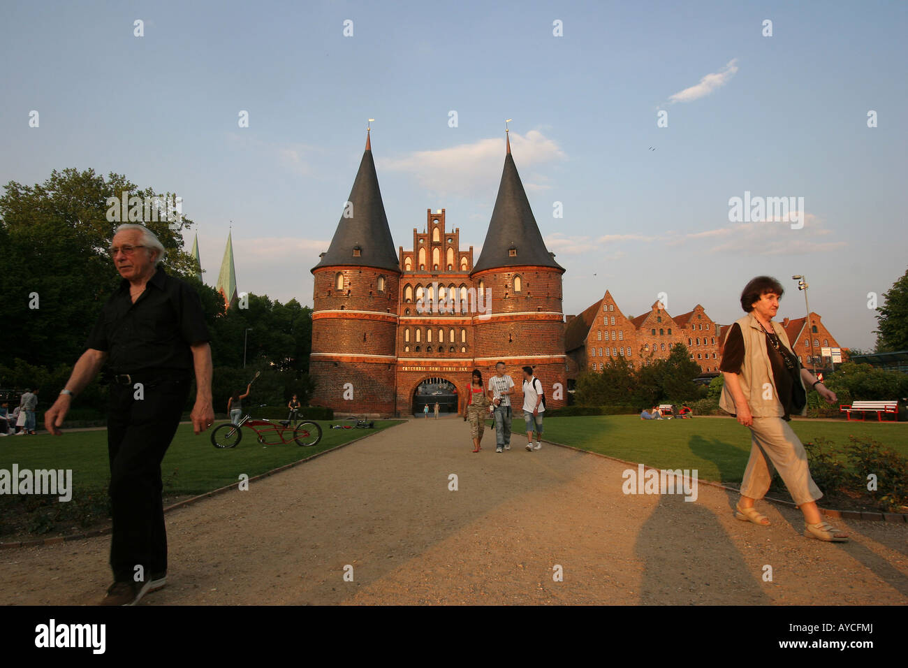 Tourists at the famous Holstentor ('Holsten Gate'), part of the medieval fortifications of Lübeck in Germany. Stock Photo