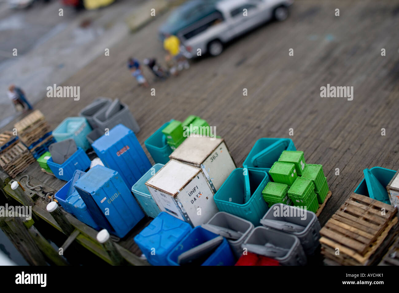 Shipping containers on a dock await transport next to the ferry in