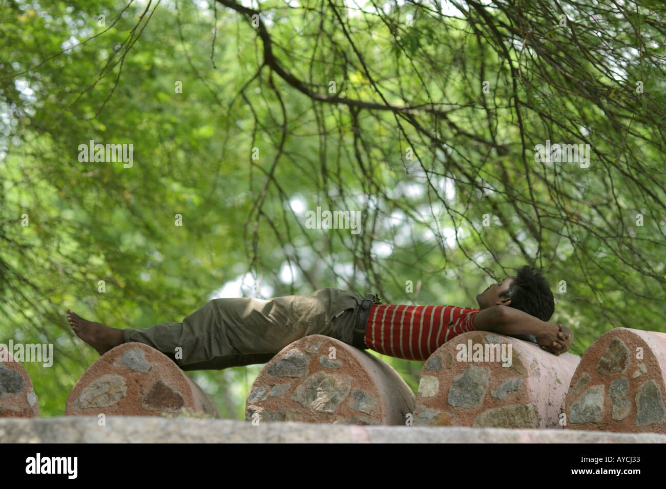 A man spleeping in a not very confortable position, India Stock Photo