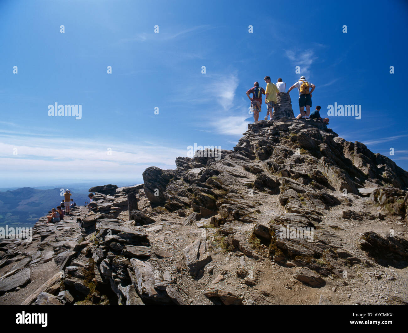 Walkers crowding on to the summit cairn of Mt Snowdon Snowdonia National Park North Wales Stock Photo