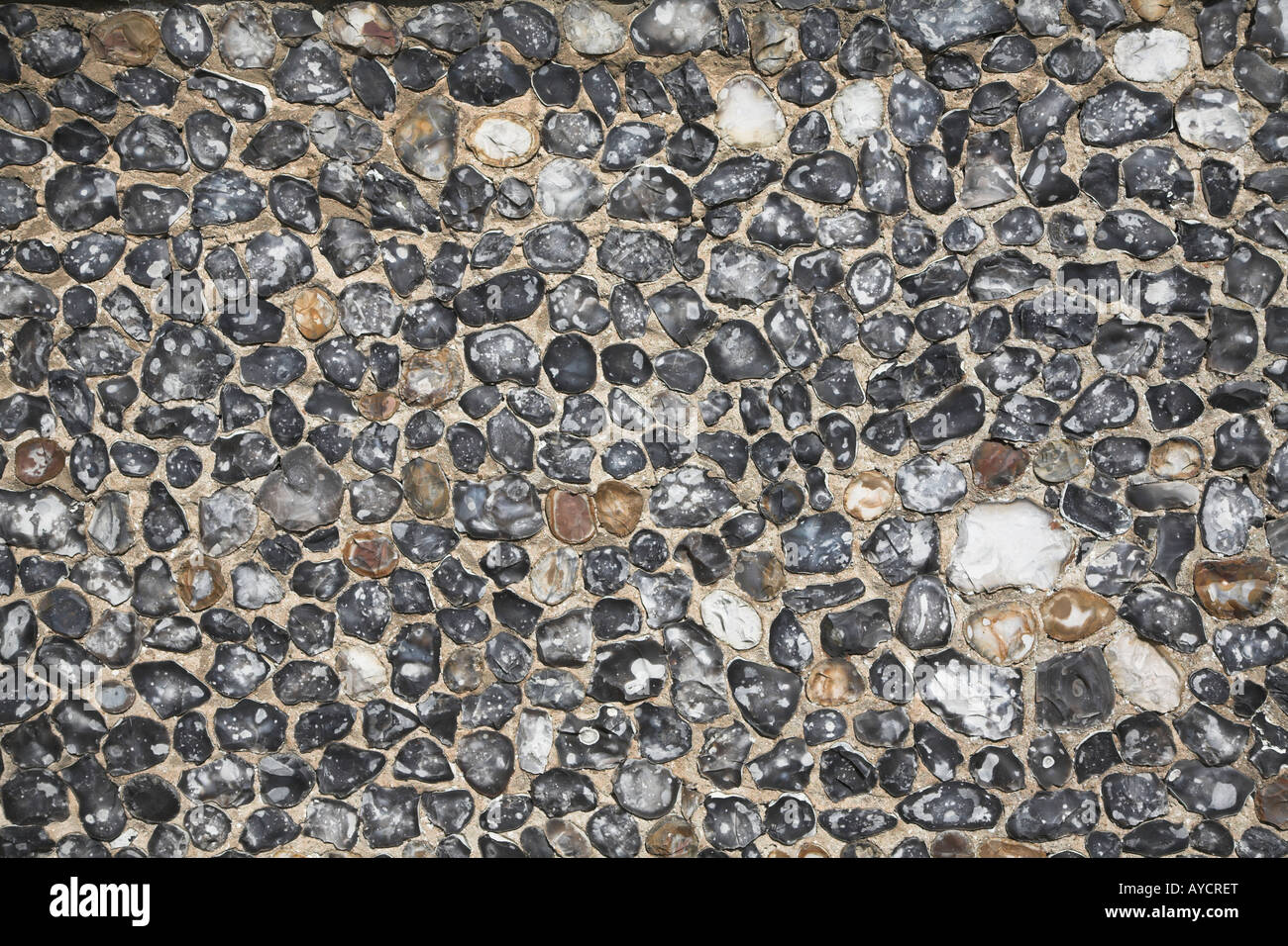 Split cobbles and flint pebbles used in wall Stock Photo