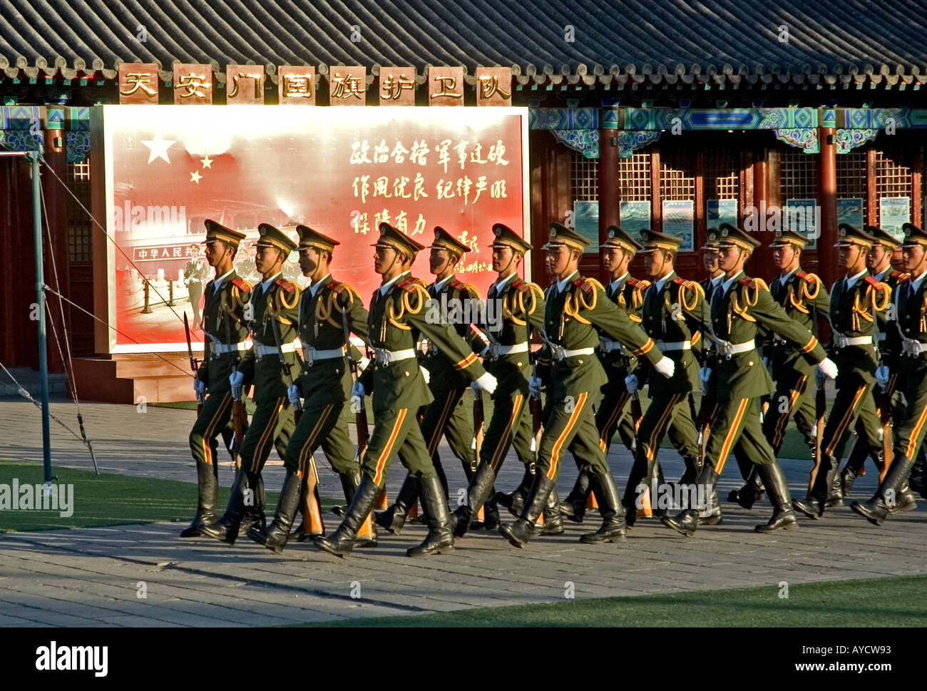 Soldiers practising military marching under a propaganda billboard, near Beijing’s Forbidden City and Tiananmen square, China Stock Photo