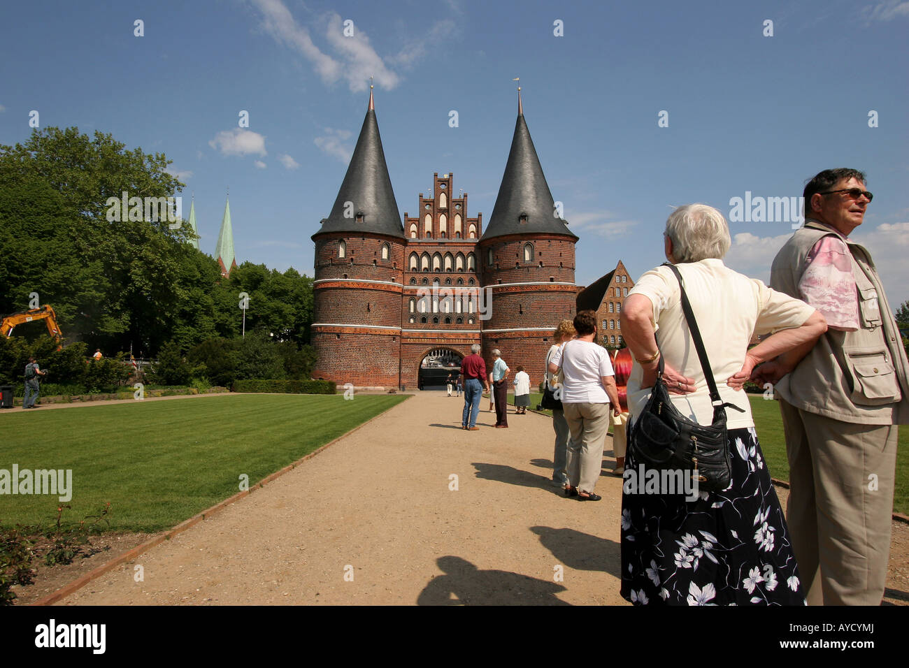 Tourists at the famous Holstentor ('Holsten Gate') , part of the medieval fortifications of Lübeck in Germany. Stock Photo
