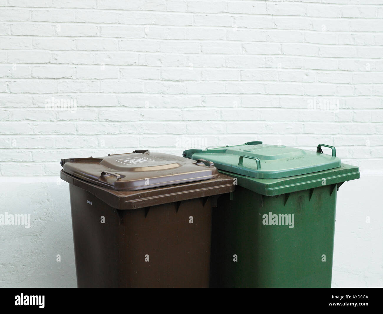 Rubbish bins against white brick wall Stock Photo Alamy