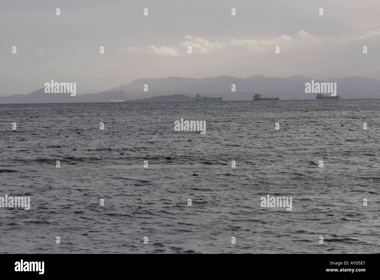 Looking from Fife across the Firth of Forth to ships off Inchkeith Island and Leith, Edinburgh and the Lammermuirs beyond. Stock Photo