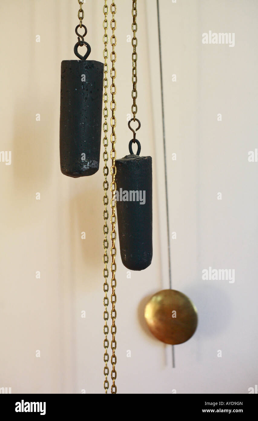Pendulum of a clock and weights on chains Stock Photo Alamy