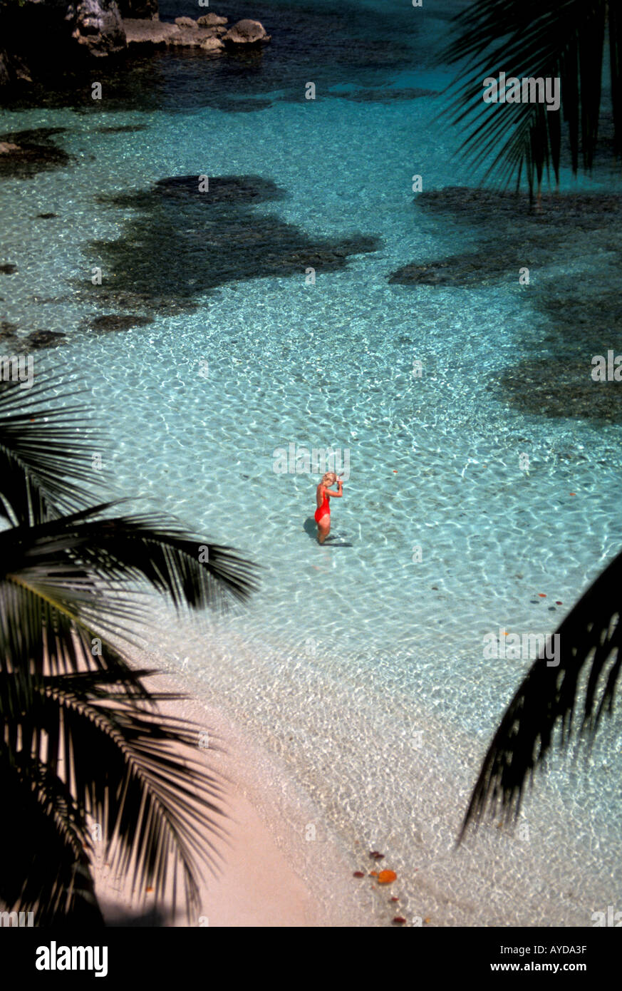 Woman snorkeler wearing red bathing suit in remote tropical cove Jamaica north shore in Caribbean Stock Photo