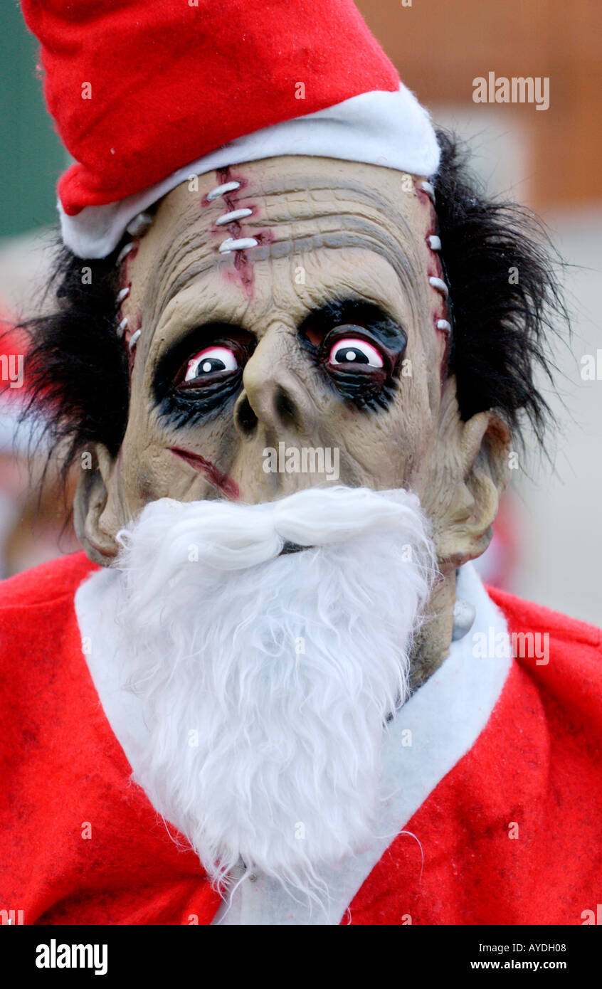 Person in a monster mask dressed as Santa Claus for the annual charity Santa Fun Run at Newtown Powys Wales UK Stock Photo