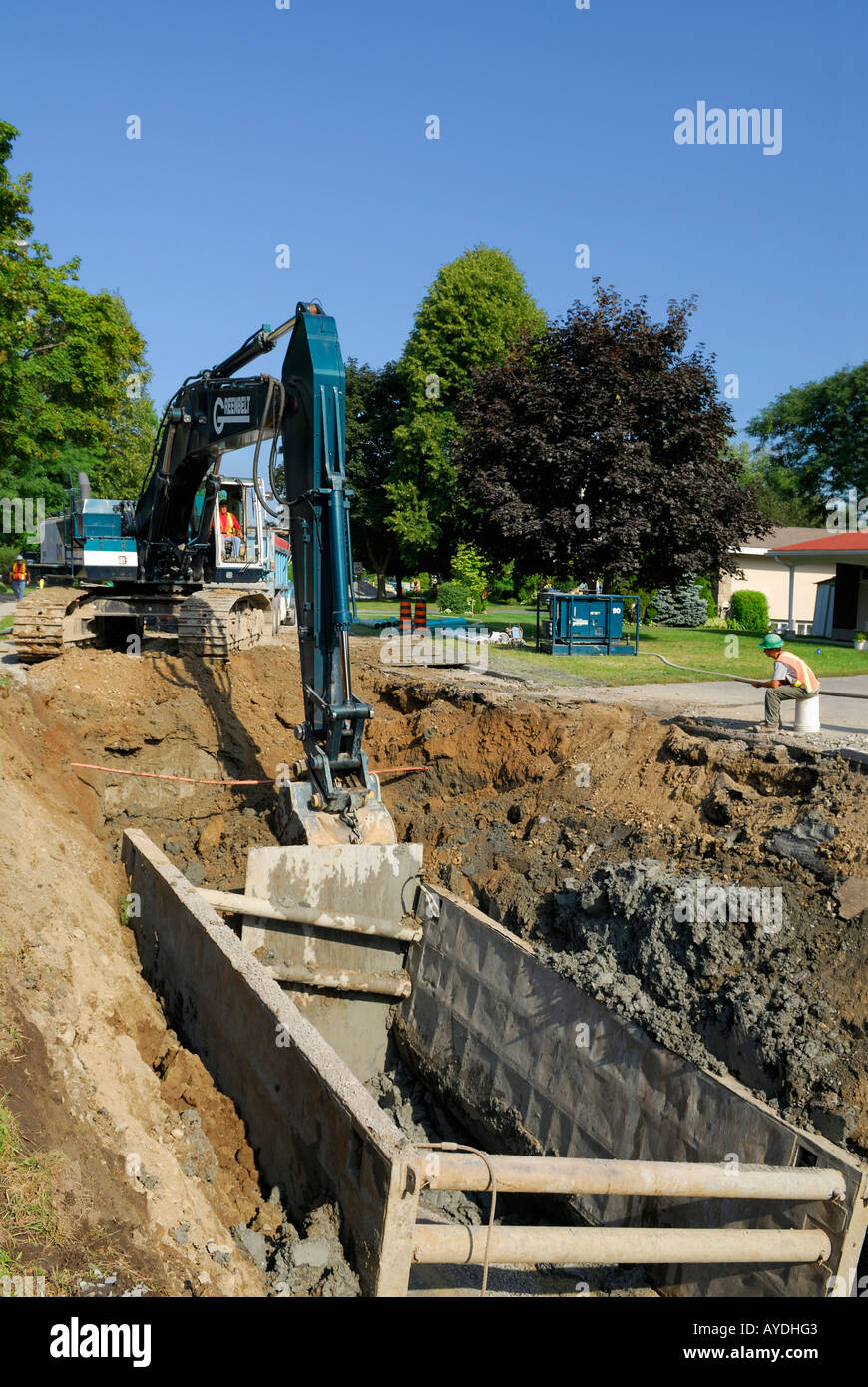 Excavator digging around a live gas line in a suburban neighbourhood Ottawa Stock Photo
