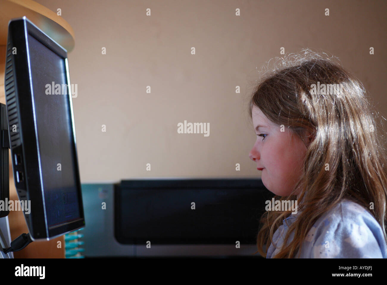 Eight year old girl concentrating on computer screen Stock Photo - Alamy