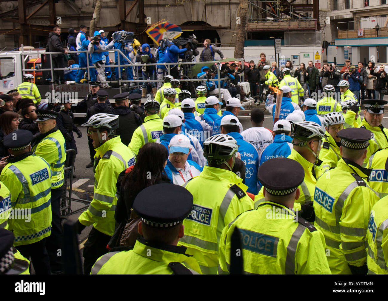 The Beijing 2008 Olympic Torch Carrier Surrounded by Policemen Stock