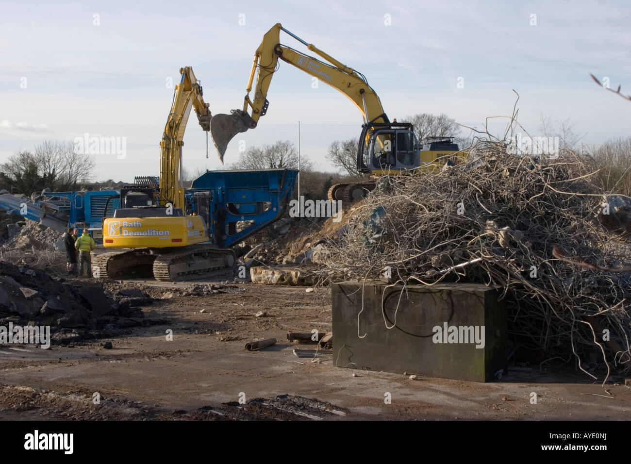 Heavy plant machines breaking up the concrete base of a brownfield construction site Stock Photo