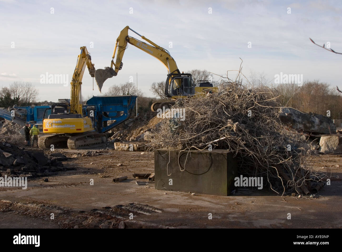 Heavy plant machines breaking up the concrete base of a brownfield construction site Stock Photo