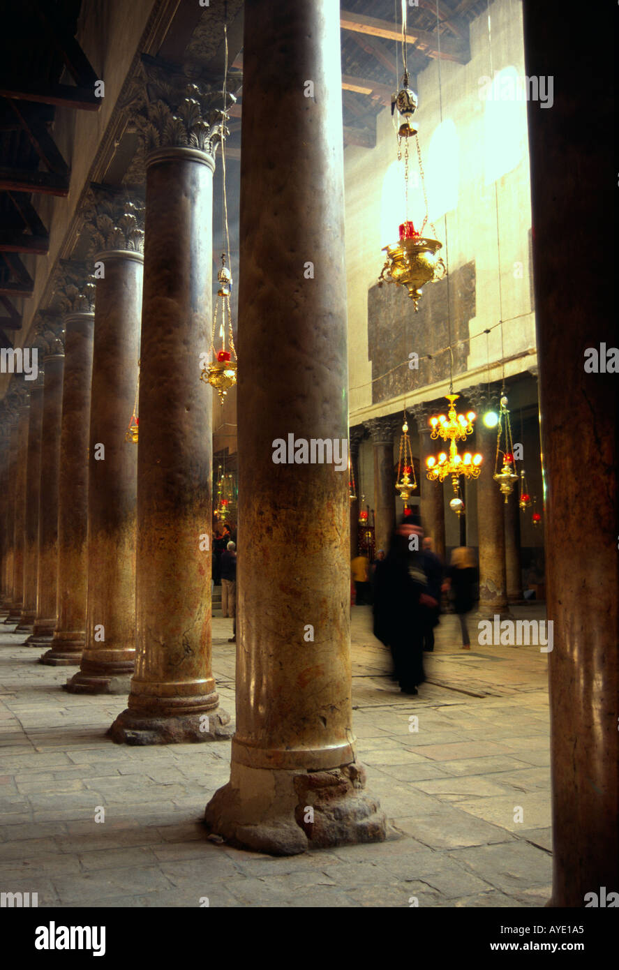 Palestinian Authority Bethlehem Church of the Nativity interior view with columns and walking priest Vert Stock Photo