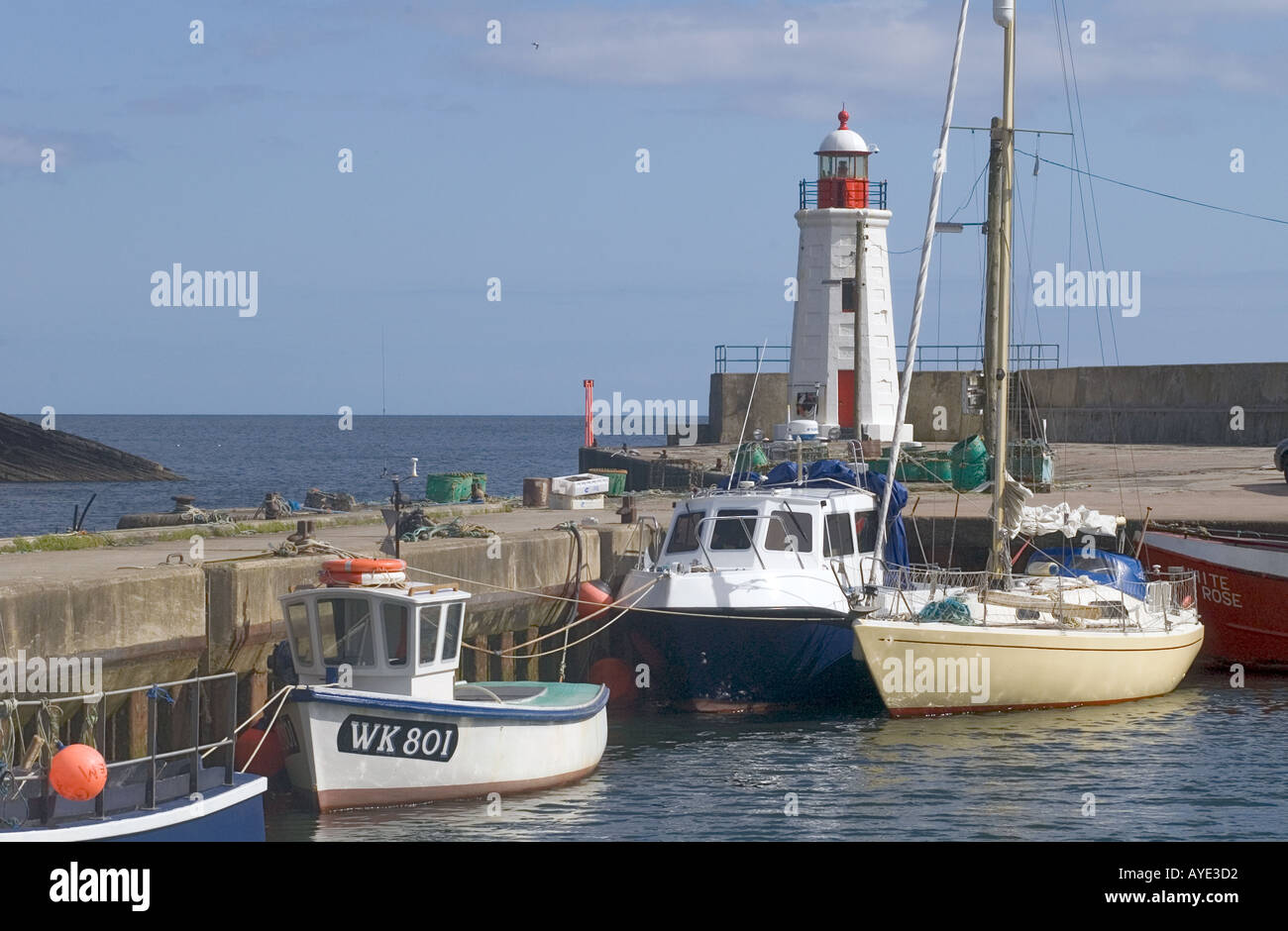 dh Harbour Lighthouse tower LYBSTER CAITHNESS Boats at quayside beacon north coast 500 scotland lights coastal Stock Photo