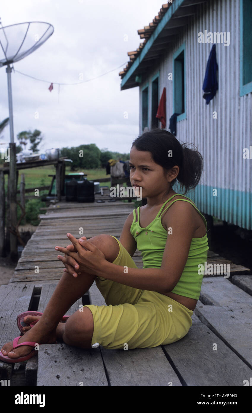 River Amazon tributary.Eliane sitting on house porch Stock Photo