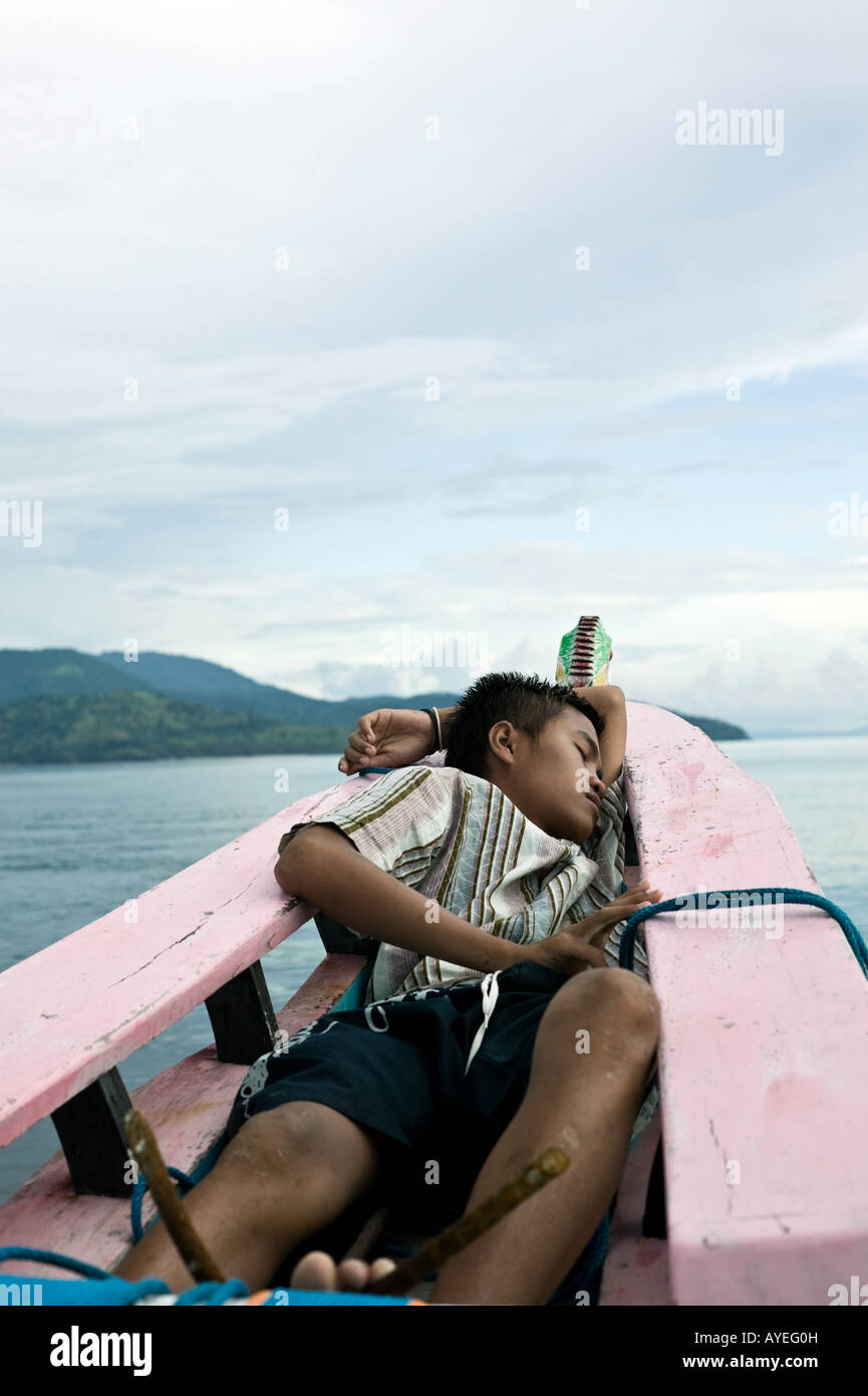 fisherman's son sleeps on the bow of an Indonesian Proa Stock Photo