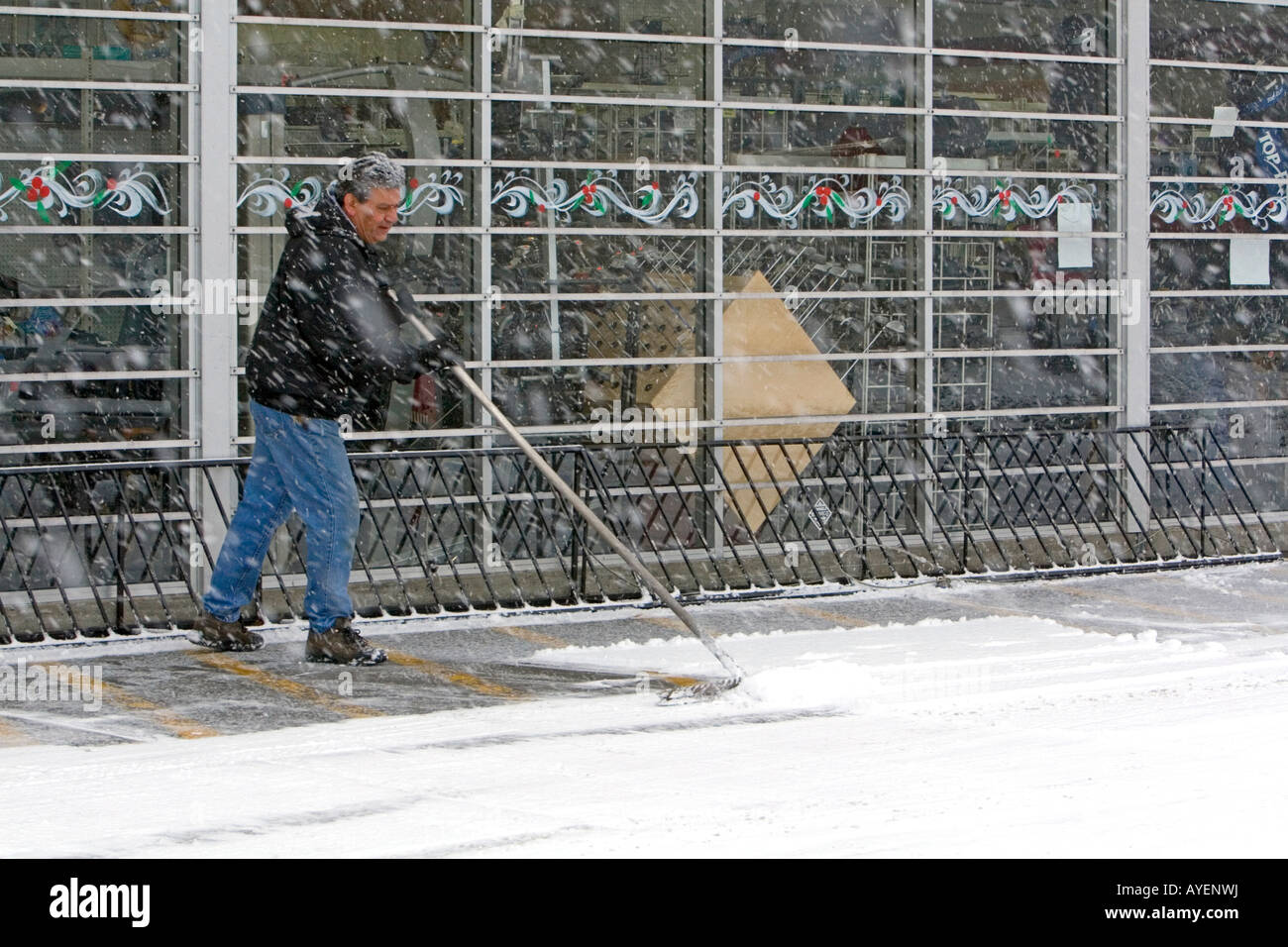 Man shoveling snow in front of a business in Boise Idaho Stock Photo