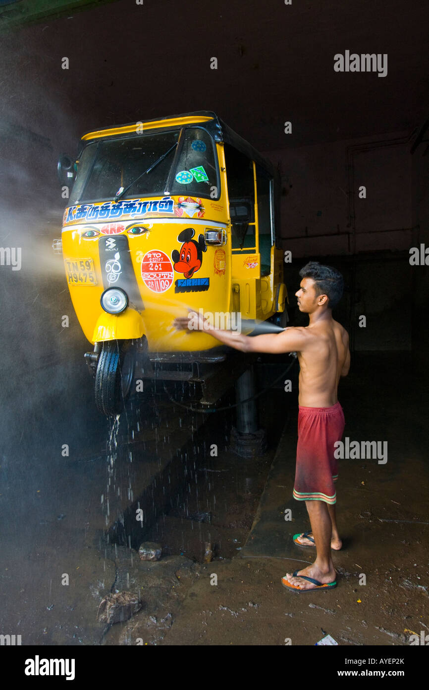 Young Indian Man in a Repair Shop Washing an Auto Rickshaw in Madurai