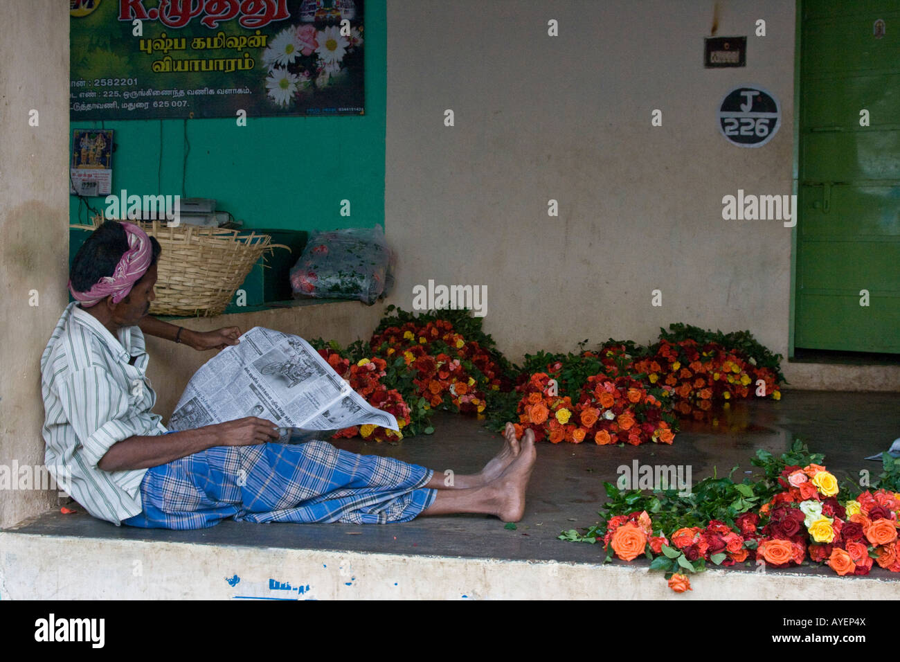 Man Reading a Newspaper in the Flower Market in Madurai South India Stock Photo