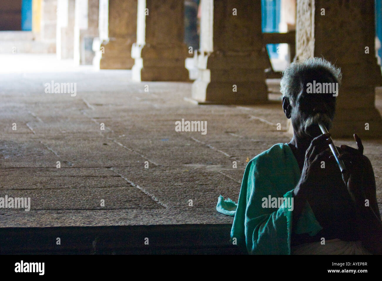 Man Playing Flute inside Hindu Temple at the Fort in Tirumayam India in Tamil Nadu Stock Photo