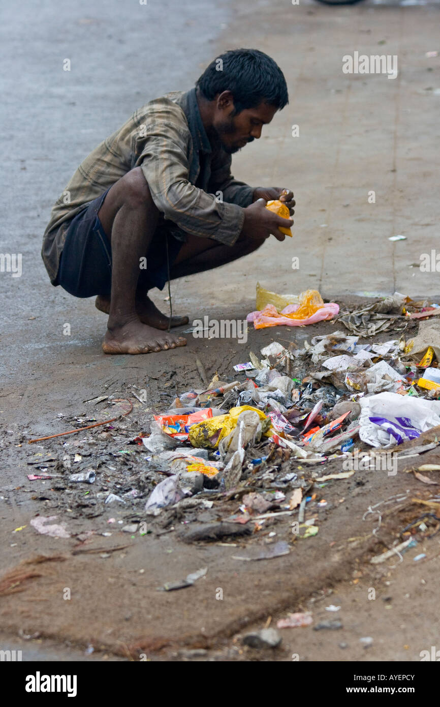 Homeless Indian Man Eating in the Streets in Tiruchirappalli or Trichy South India Stock Photo