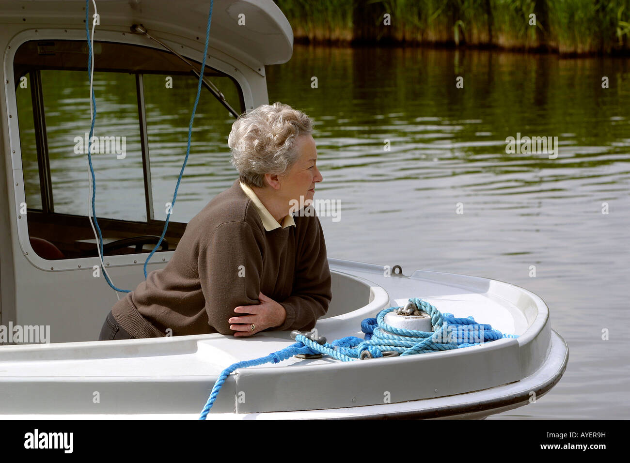 UK Norfolk Broads Ludham River Ant woman relaxing on rental boat Stock