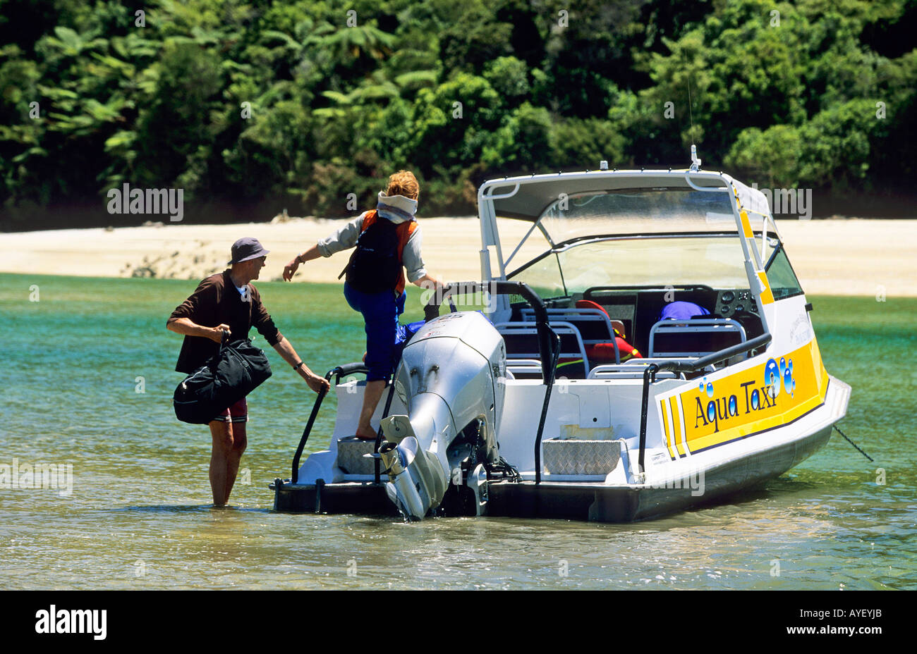 Tourist getting on a water taxi at Awaroa Inlet in Able Tasman National ...