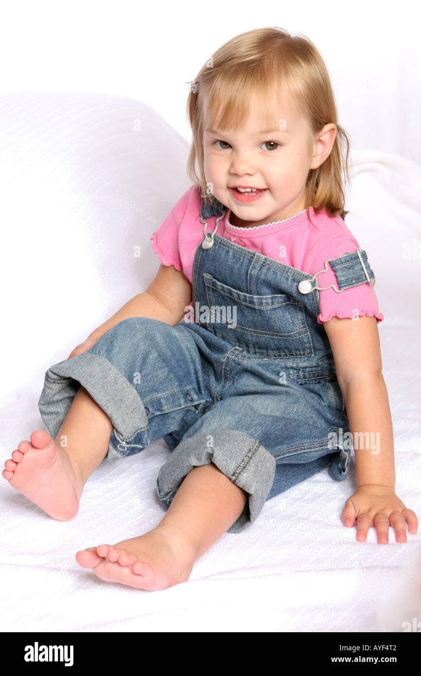 Girl sitting in overalls Stock Photo Alamy