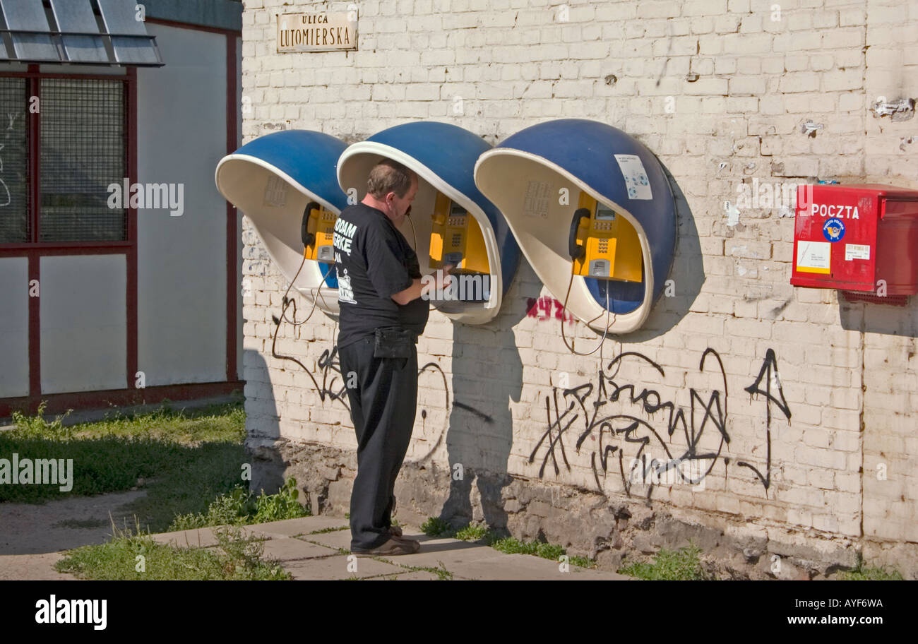 Man talking on Polish outdoor telephone next to a mailbox. Lutomierska Street Lodz Central Poland Stock Photo
