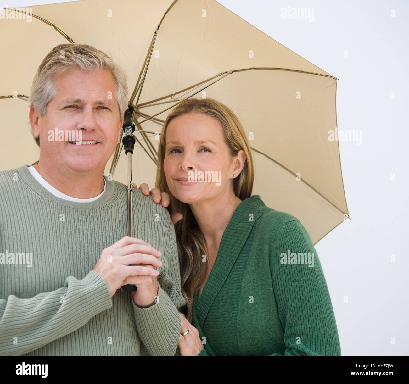 Couple standing under umbrella Stock Photo - Alamy