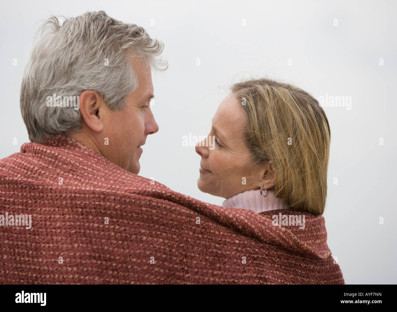 Couple wrapped in blanket Stock Photo Alamy
