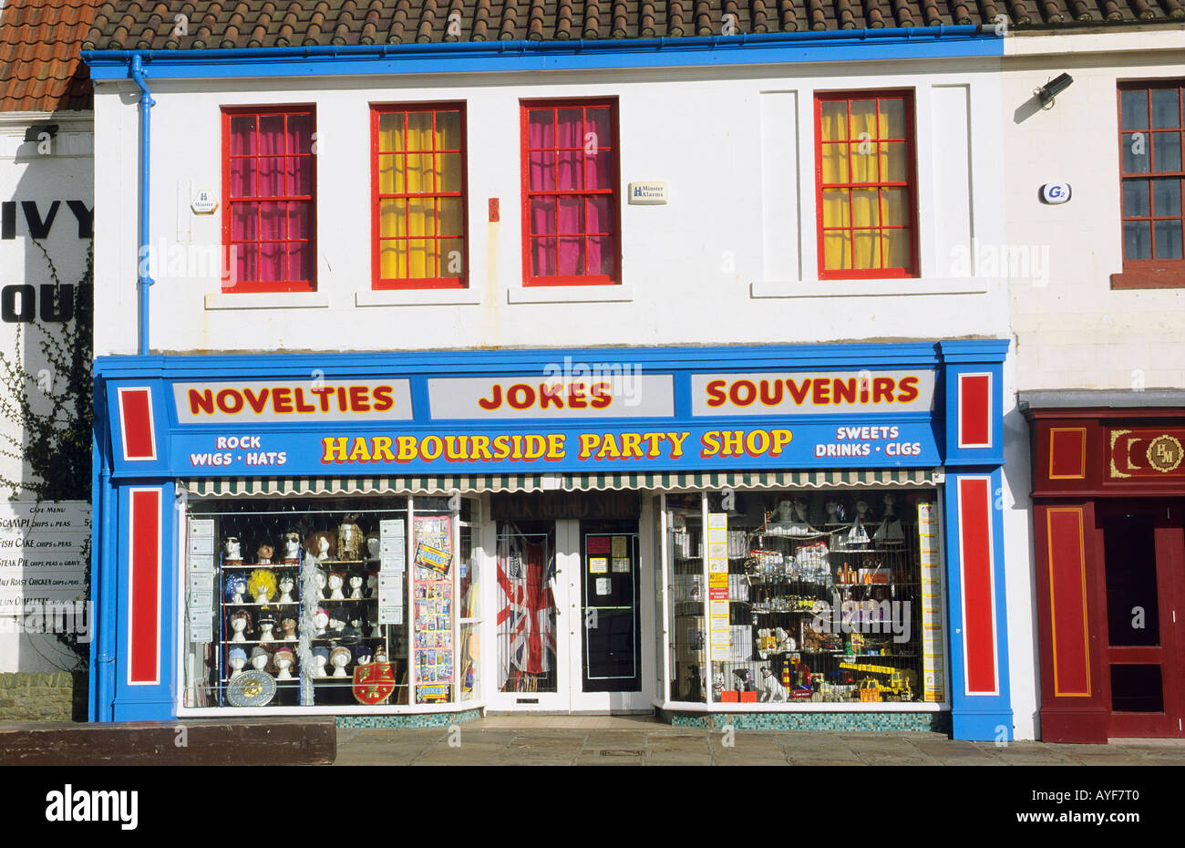The facade of a red white and blue party shop in the harbour at Scarborough Stock Photo
