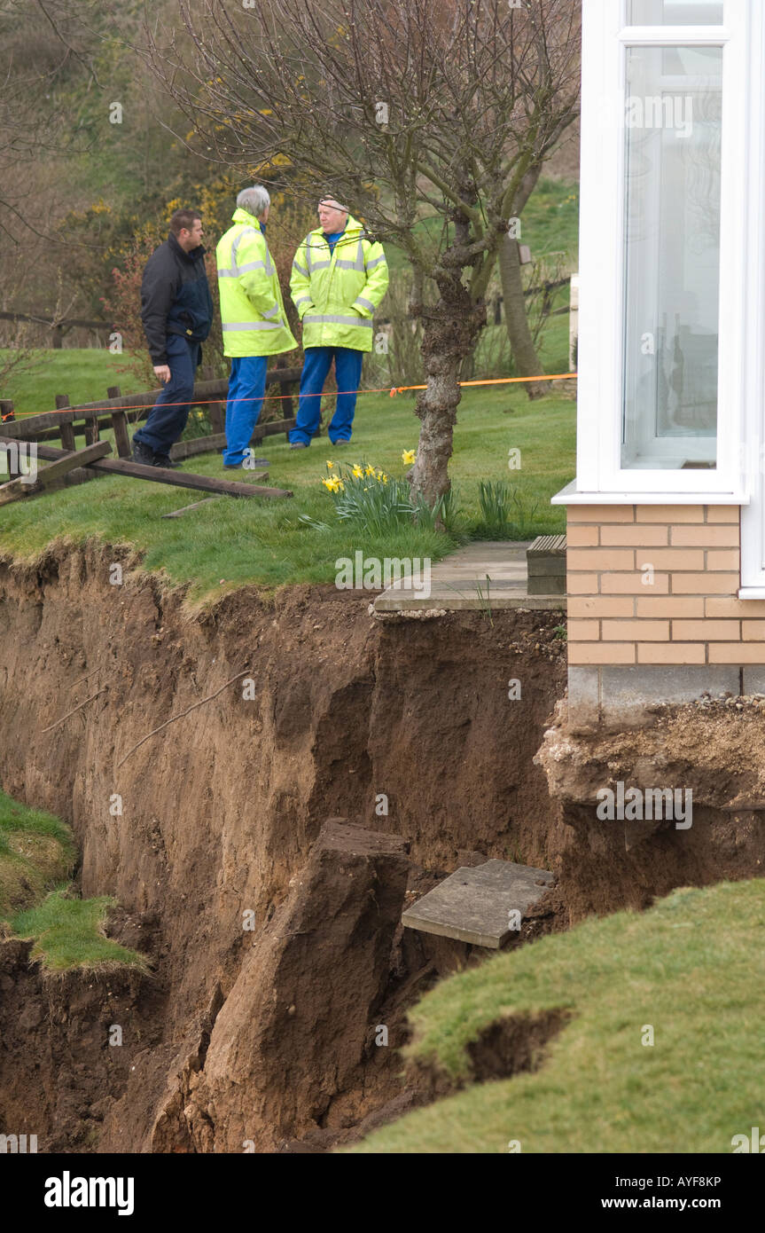 Council workers discussing landslip outside house at Knipe Point, Yorkshire, UK Stock Photo