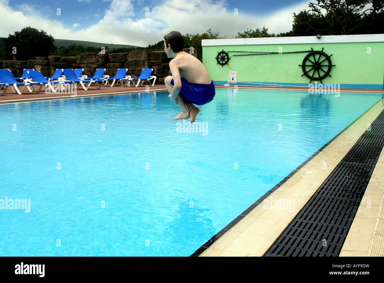 Young boy jumps into swimming pool Stock Photo Alamy