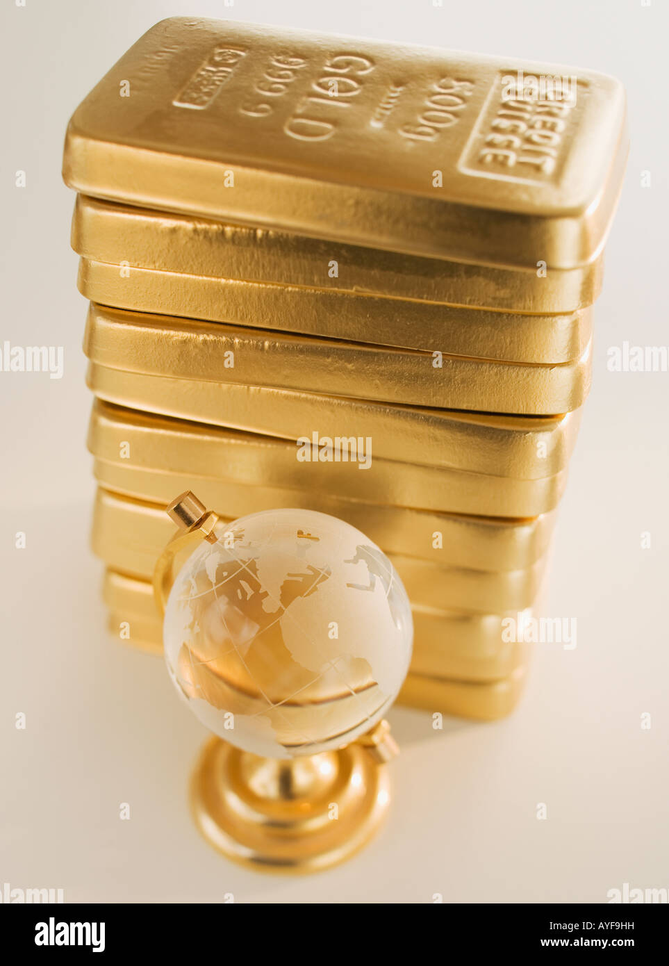 Globe next to stack of gold bars Stock Photo