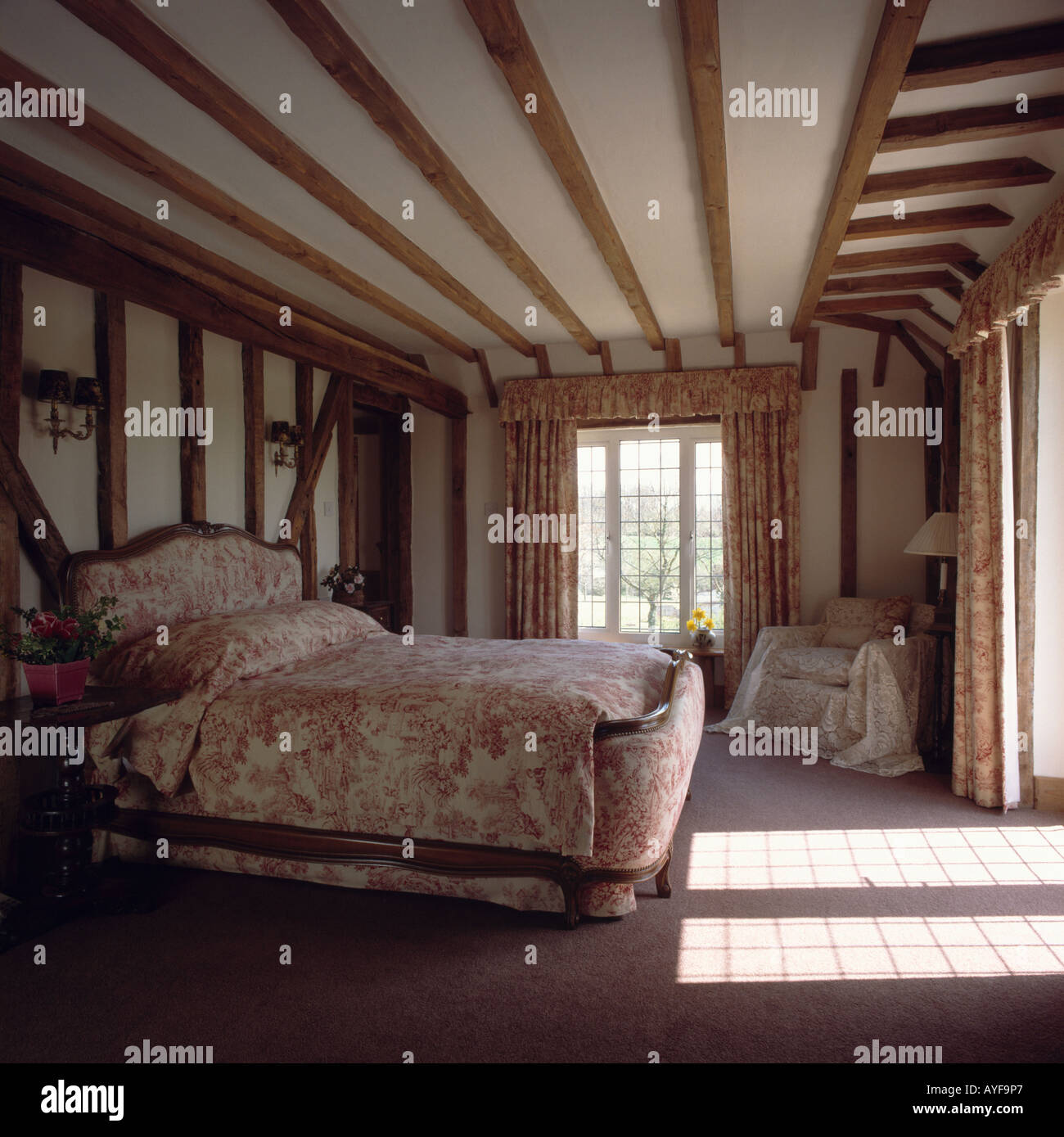 Country Bedroom With Beamed Walls And Bed With Upholstered