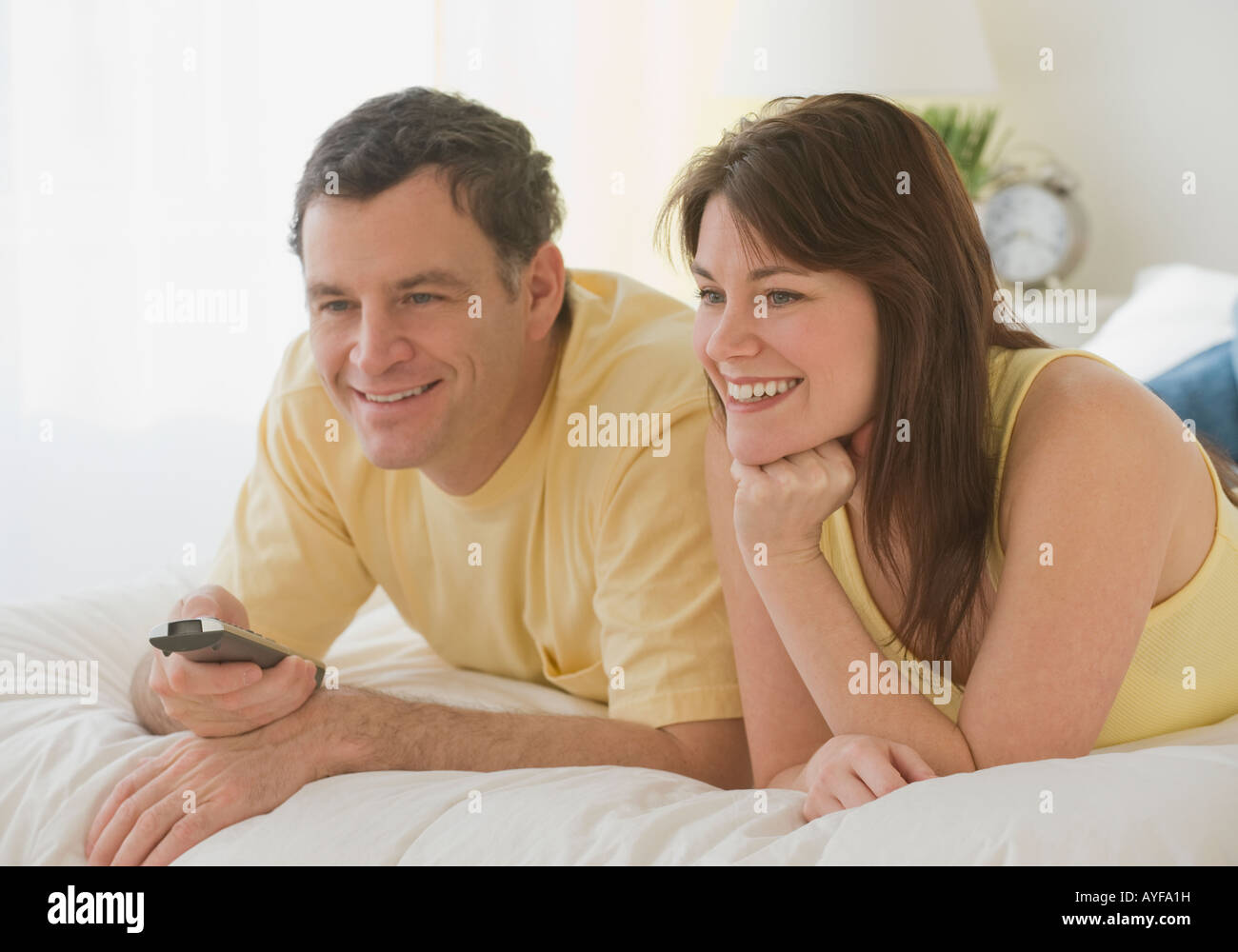 Couple pointing remote control on bed Stock Photo Alamy