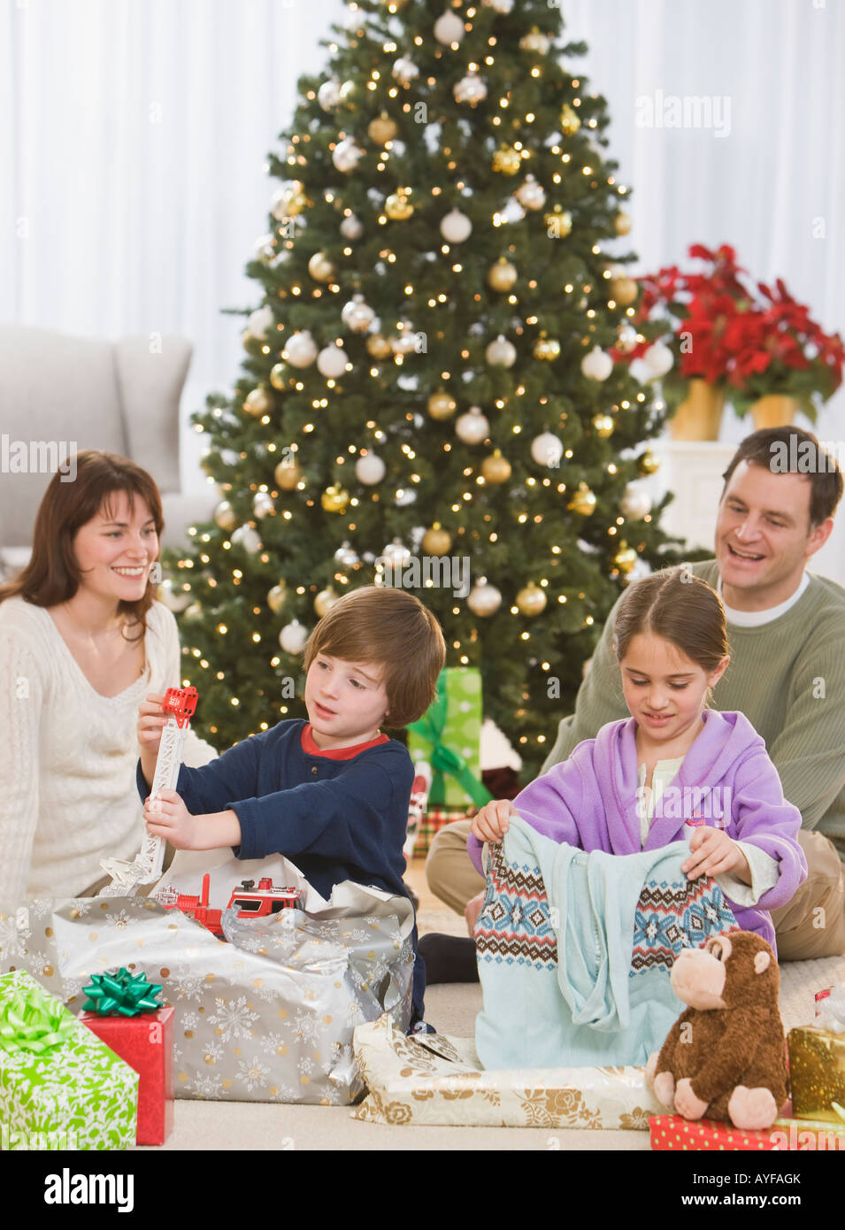 Siblings opening Christmas gifts Stock Photo - Alamy