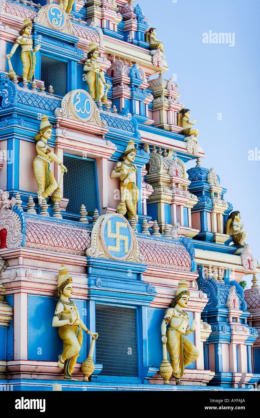 Indian gopuram temple architecture against a bright blue sky. Entrance to Sathya Sai Baba ashram. Puttaparthi, Andhra Pradesh, India Stock Photo