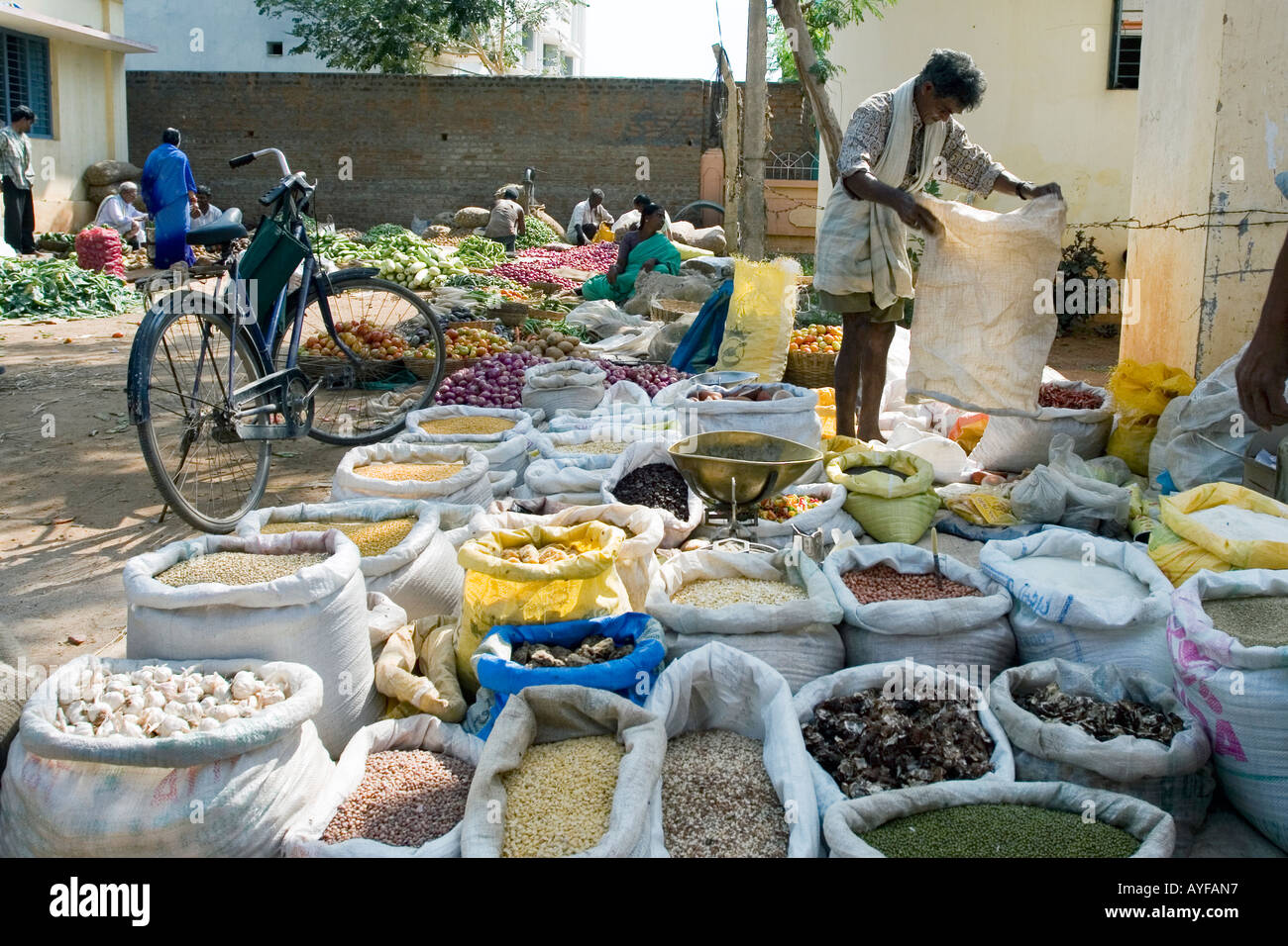 Indian market man selling sacks of food and produce in town of Puttaparthi, Andhra Pradesh, India Stock Photo